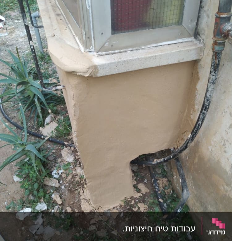 קיר מטויח עם צינורות חשופים ועבודת שיפוץ